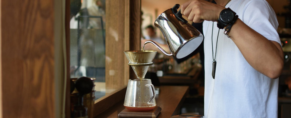 BARISTA USING POUR OVER KETTLE TO MAKE DRIP COFFEE BANNER