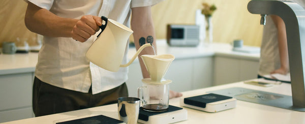 KINTO Journal Article Barista using POUR OVER KETTLE to brew coffee with OCT brewer and coffee jug 